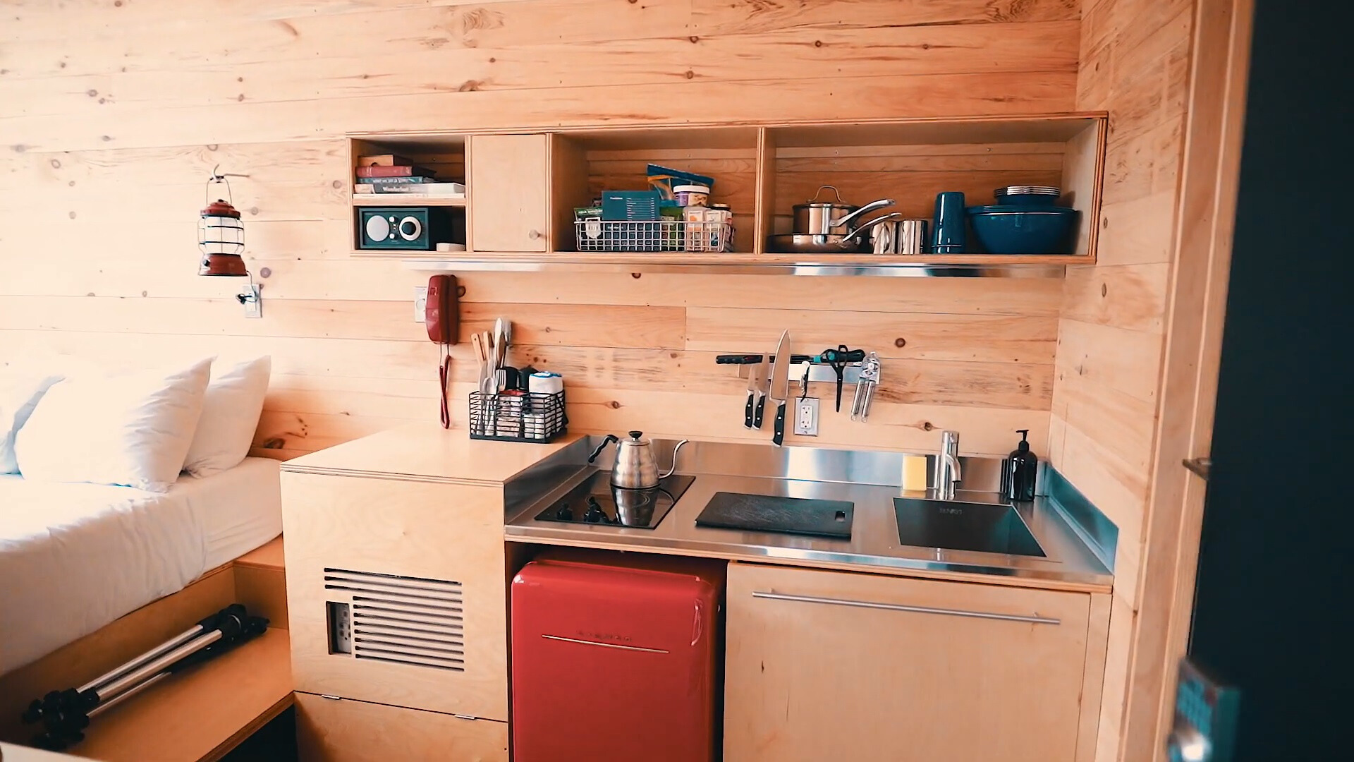 kitchen with wooden cabinets, wooden shelves and a red fridge