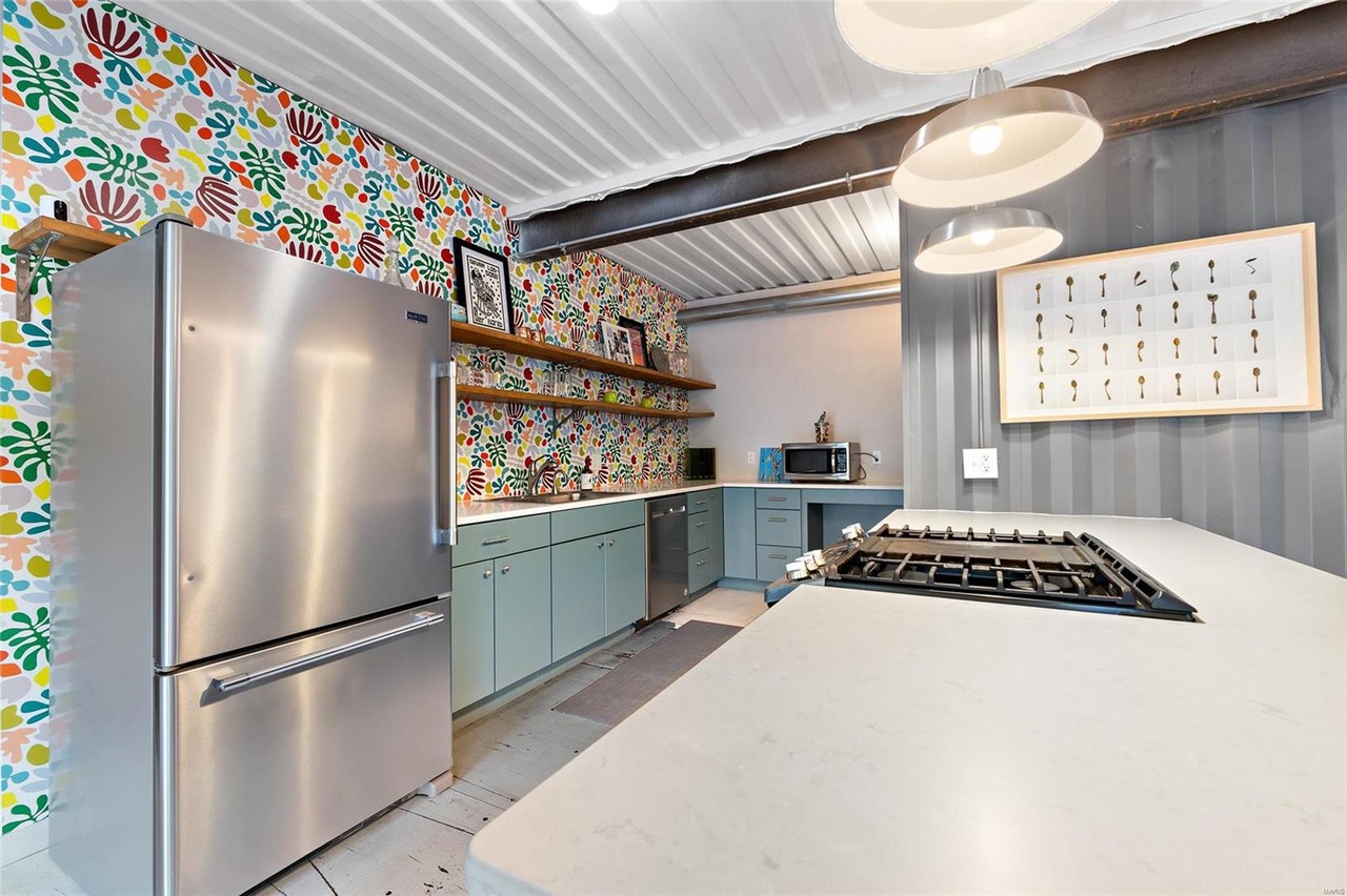 kitchen with a colorful wall, teal cabinets and an island with a white countertop