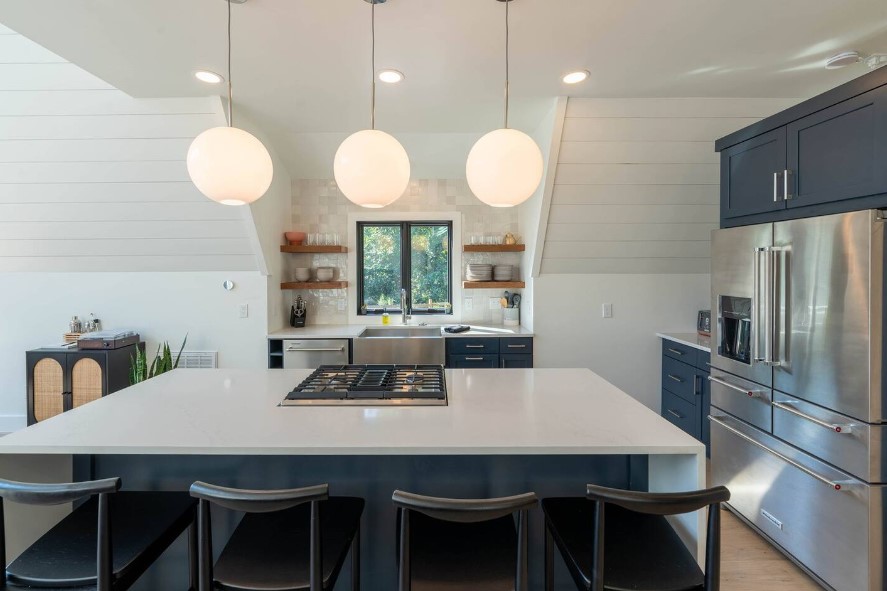 kitchen with white countertops, blue cabinets, a big island and a window