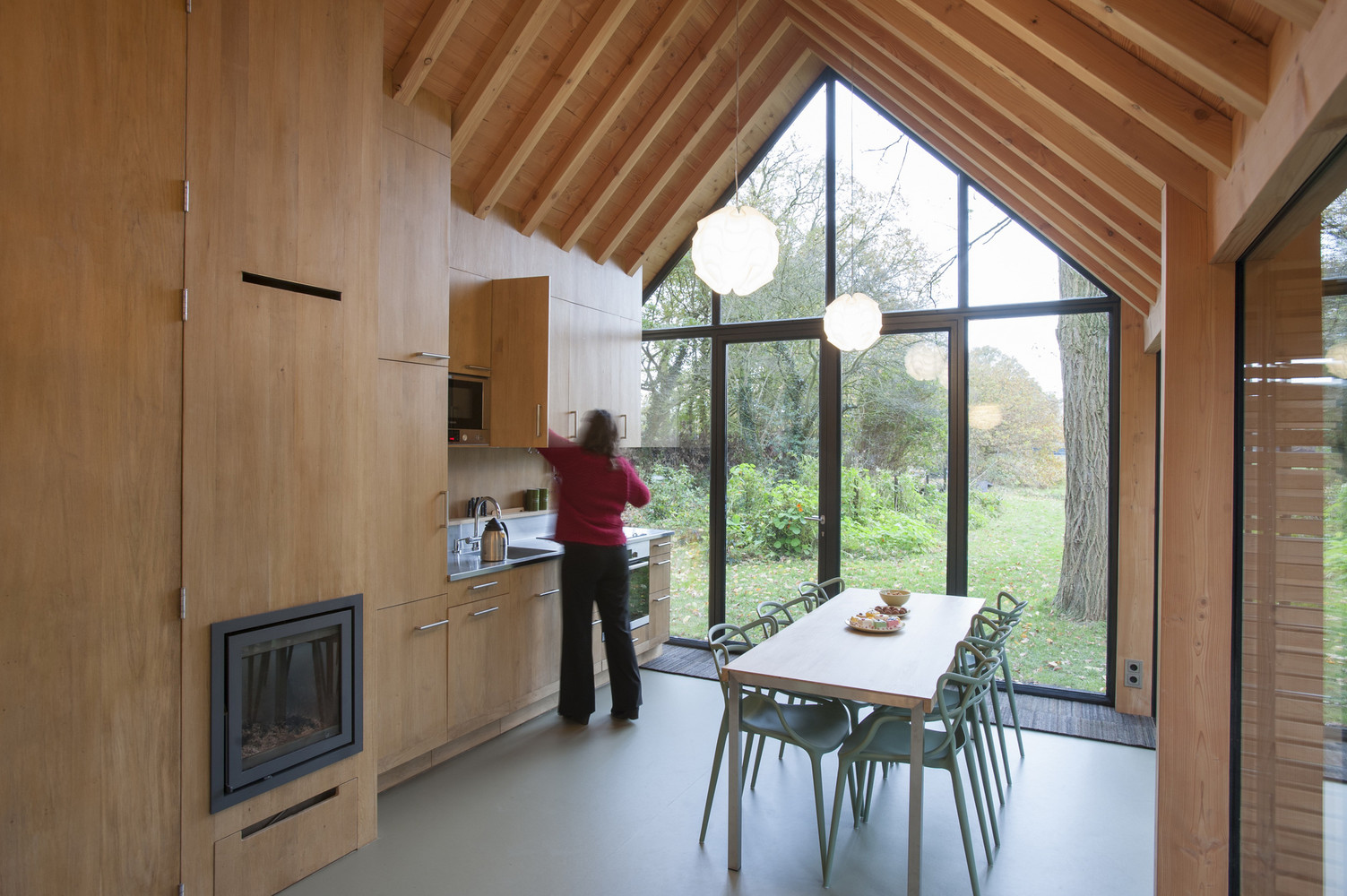 kitchen with brown cabinets, dining table accompanied by chairs and floor to ceiling windows