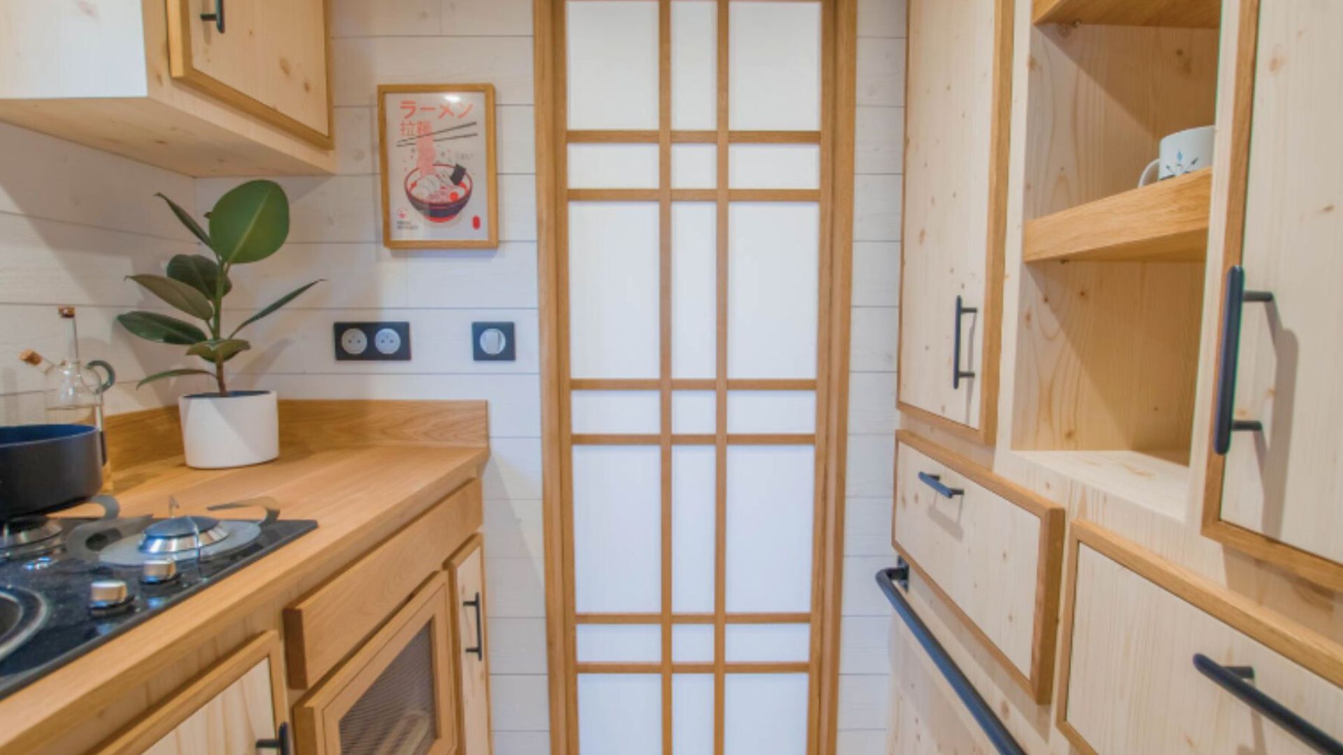 small kitchen with wooden cabinets, a small stove, washi door closed