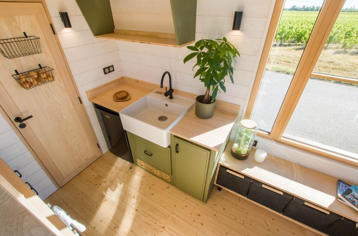 kitchen with green cabinets, brown countertop and a white sink