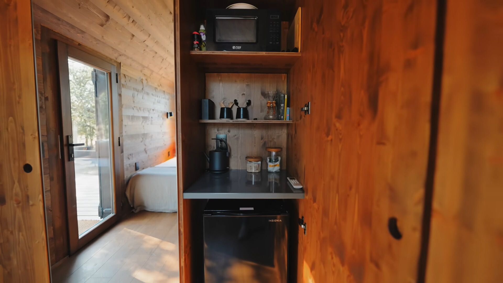 kitchenette with utensils, microwave and a fridge