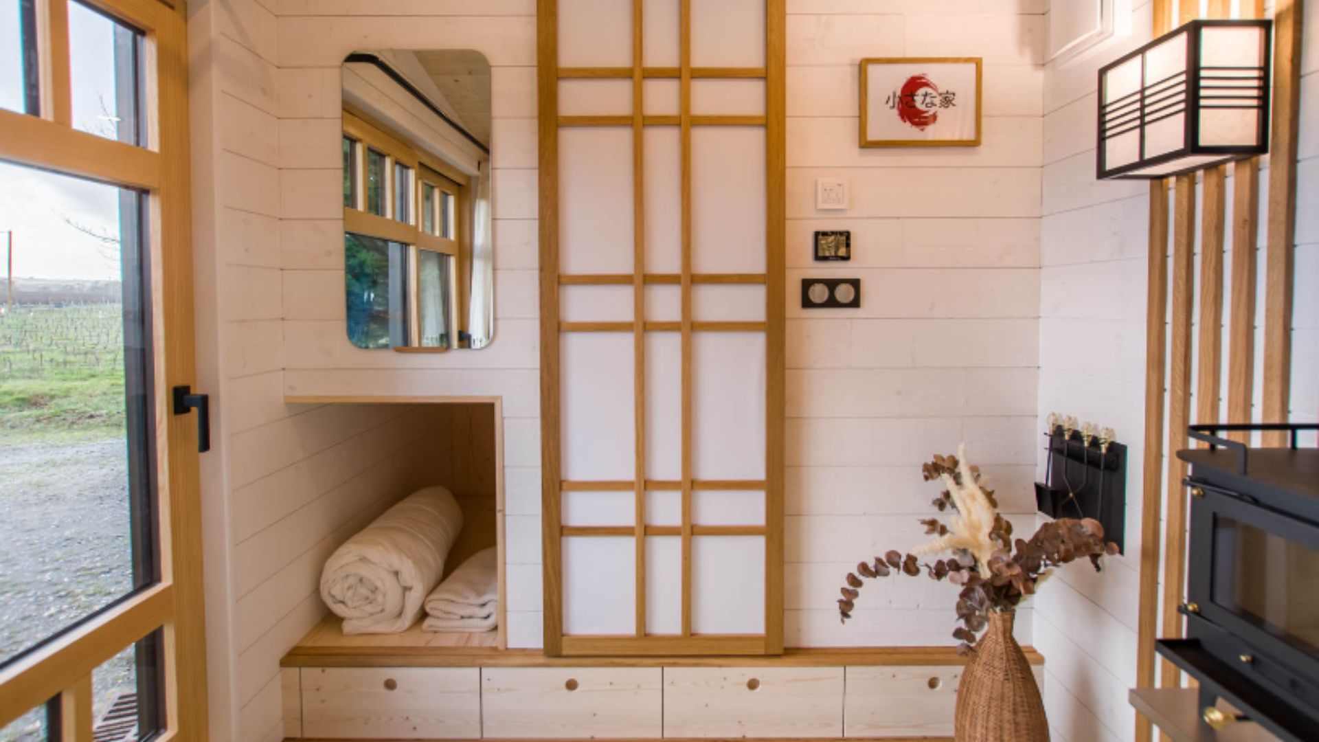 living room area with built-in shelves and a washi door with a futon bed behind it, fireplace visible on the right