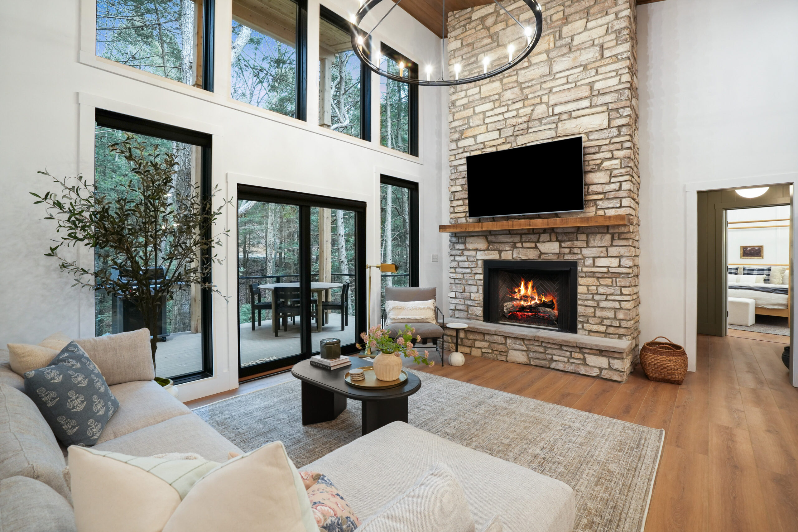 living room with a fireplace, light beige couch, flat screen tv and big windows