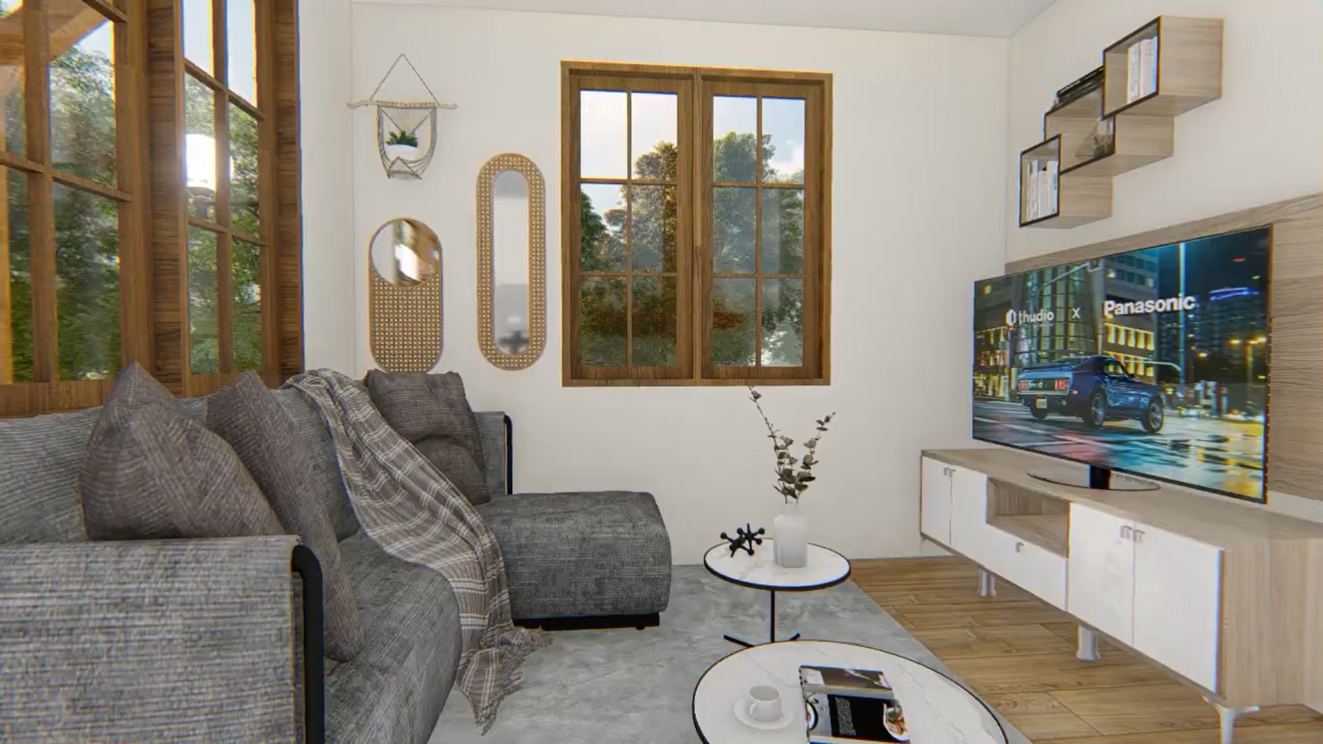 living room with an l-shaped gray couch, a flat screen tv, round small tables, shelf above the tv and unique mirrors on the wall