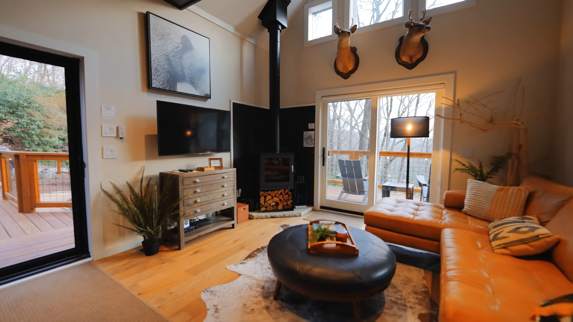 living room with an l-shaped orange couch, glass doors, black table, fireplace and a flat screen tv and a brown cabinet