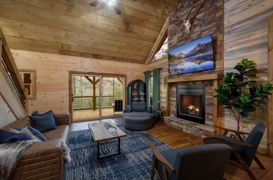 living room with a brown, leather couch, blue sofa in the corner, a mini wooden table, a fireplace and a flat screen tv