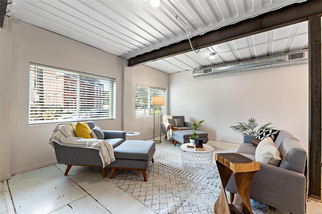 living room with a gray couch, mini white table, big windows