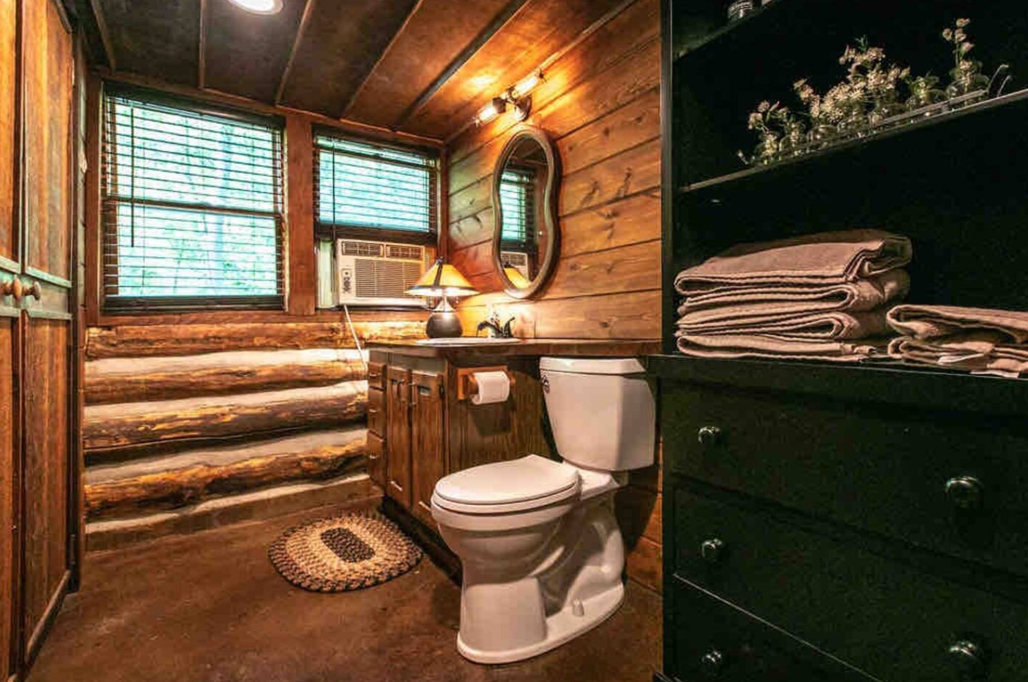 Bathroom with log walls and a green cabinet