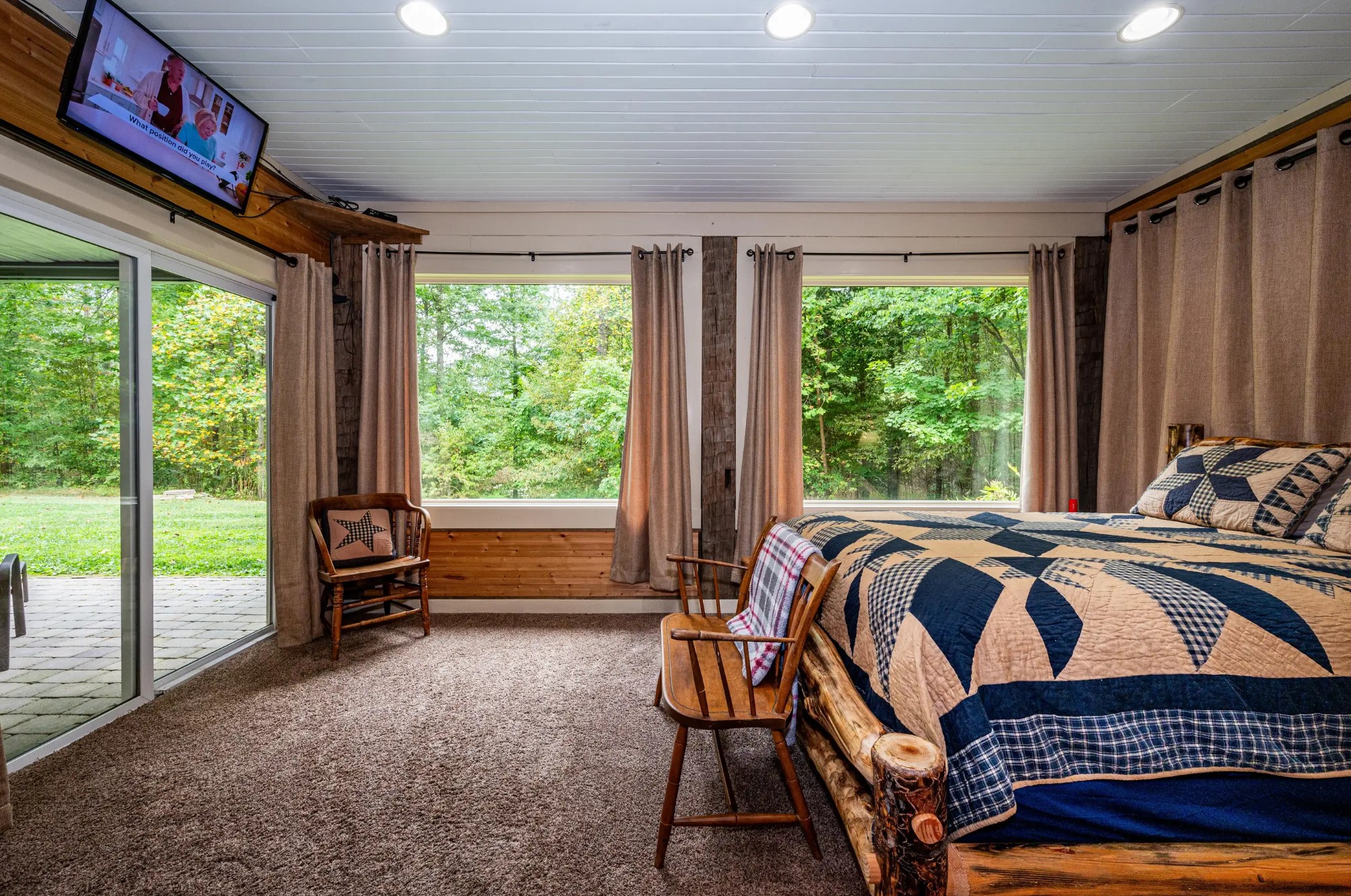 Mater bedroom with a comfortable bed, TV and huge windows