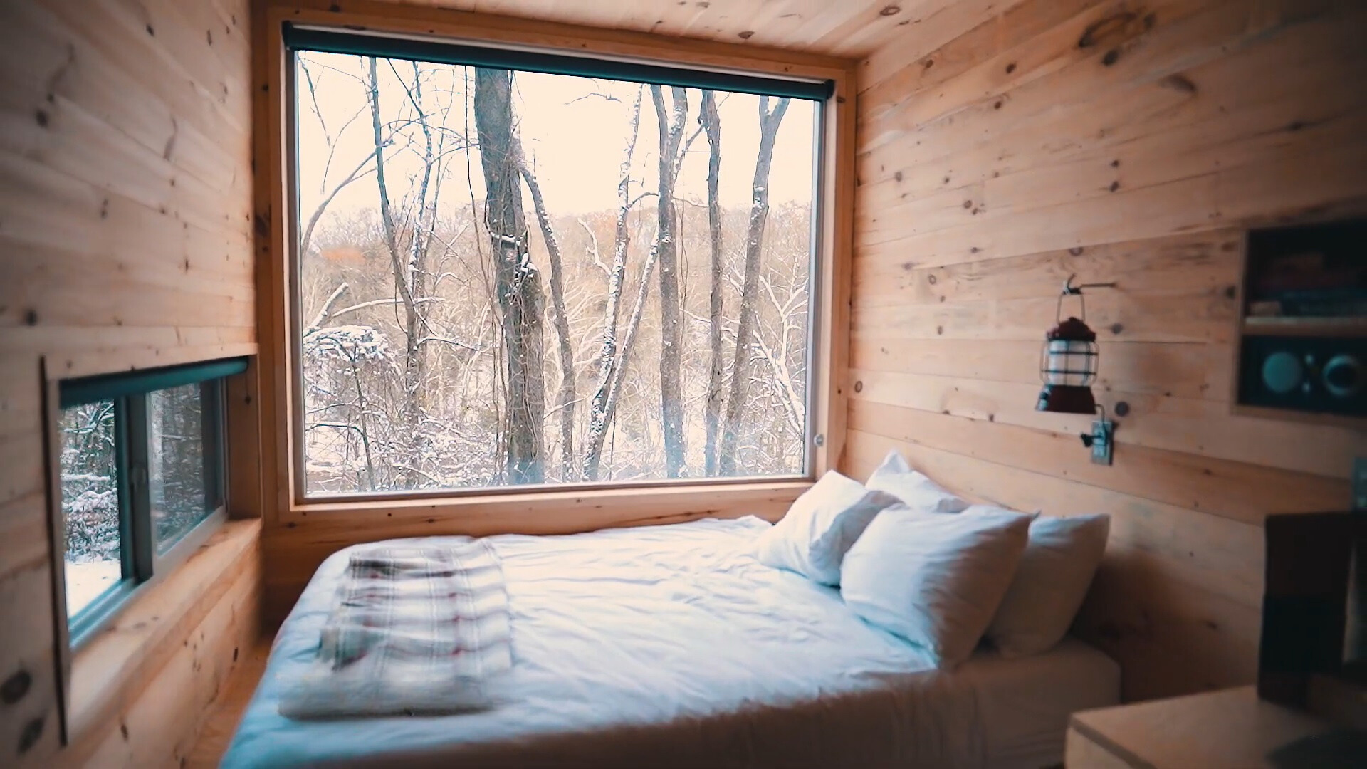 queen sized bed, brown, wooden walls and a big window