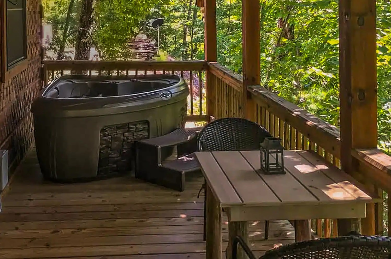 Balcony of a cabin with a corner hot tub and lunge area