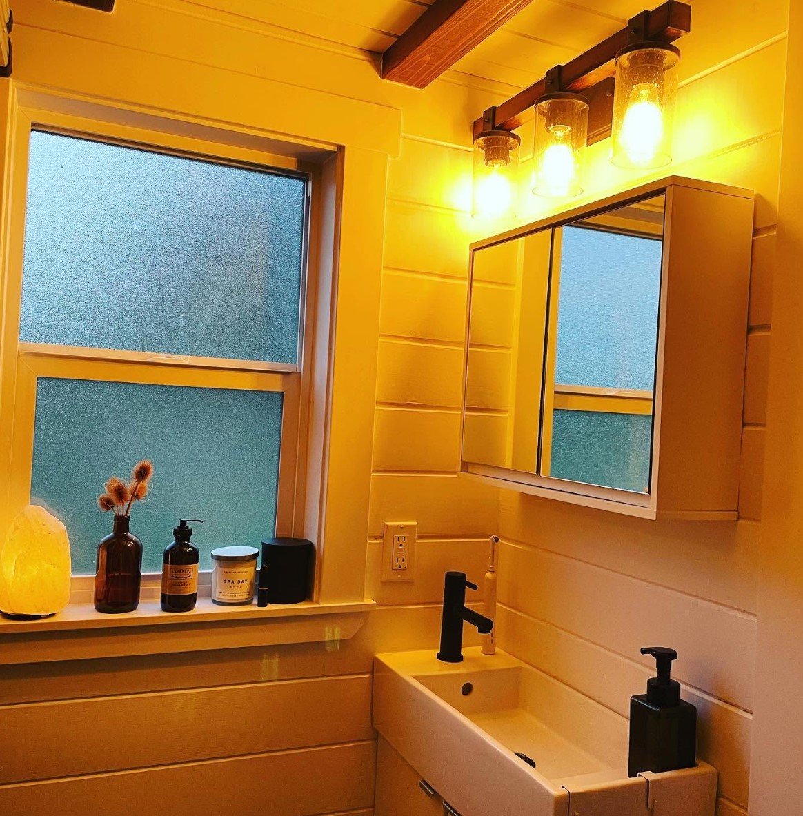 Bathroom with a small vanity and orange lights