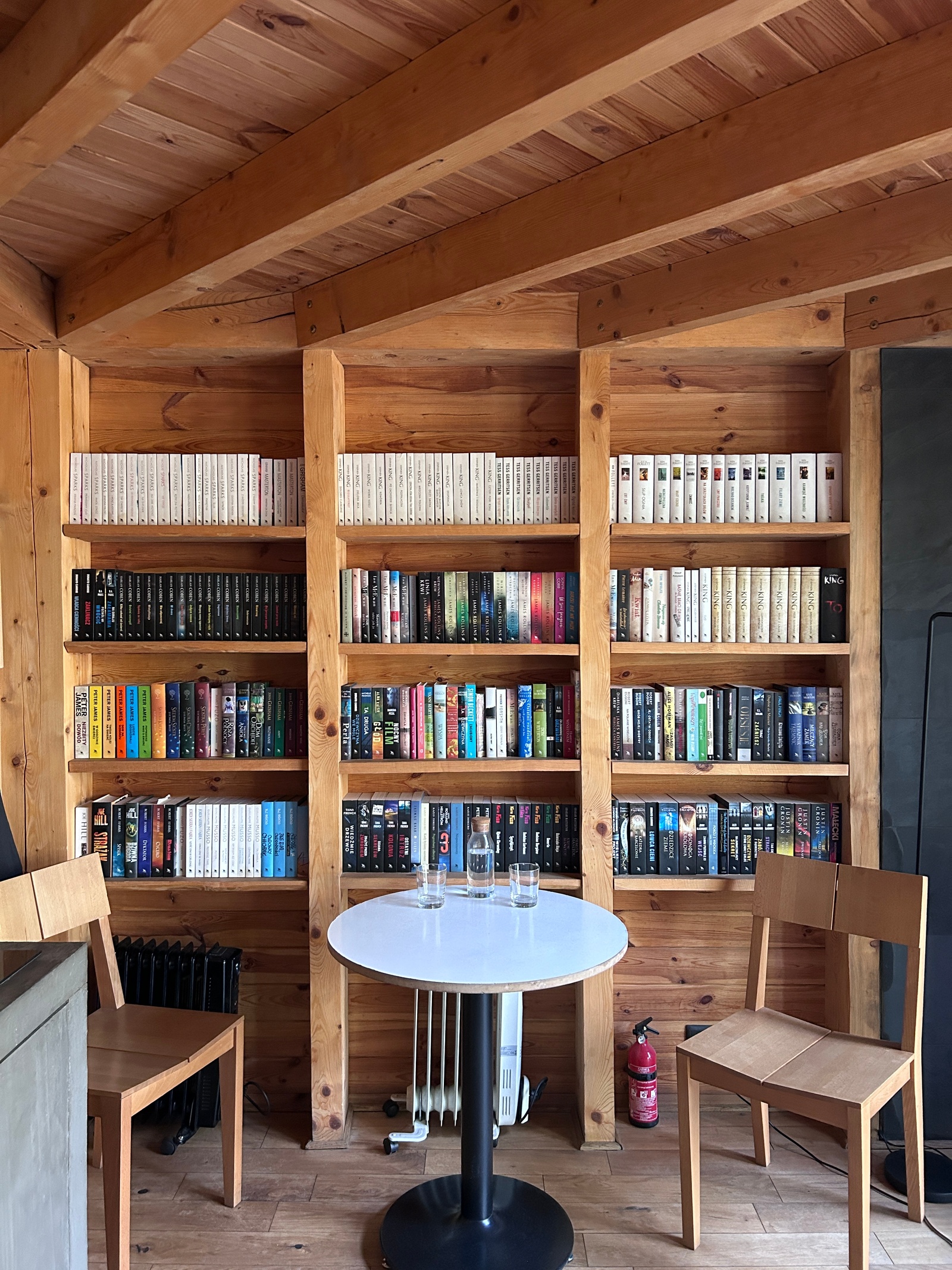 Cabin with a library, table and two chairs