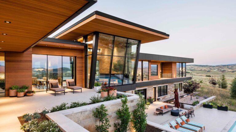 exterior of a modern house with brown walls and floor to ceiling windows