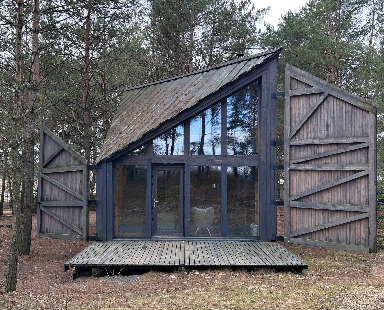 Exterior of tiny cabin with huge windows and a patio