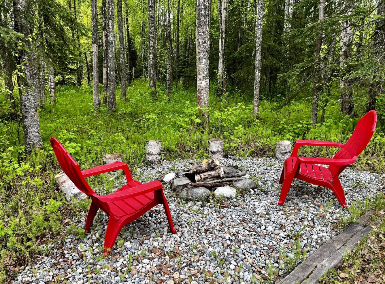 Fire pit in the backyard with red chairs