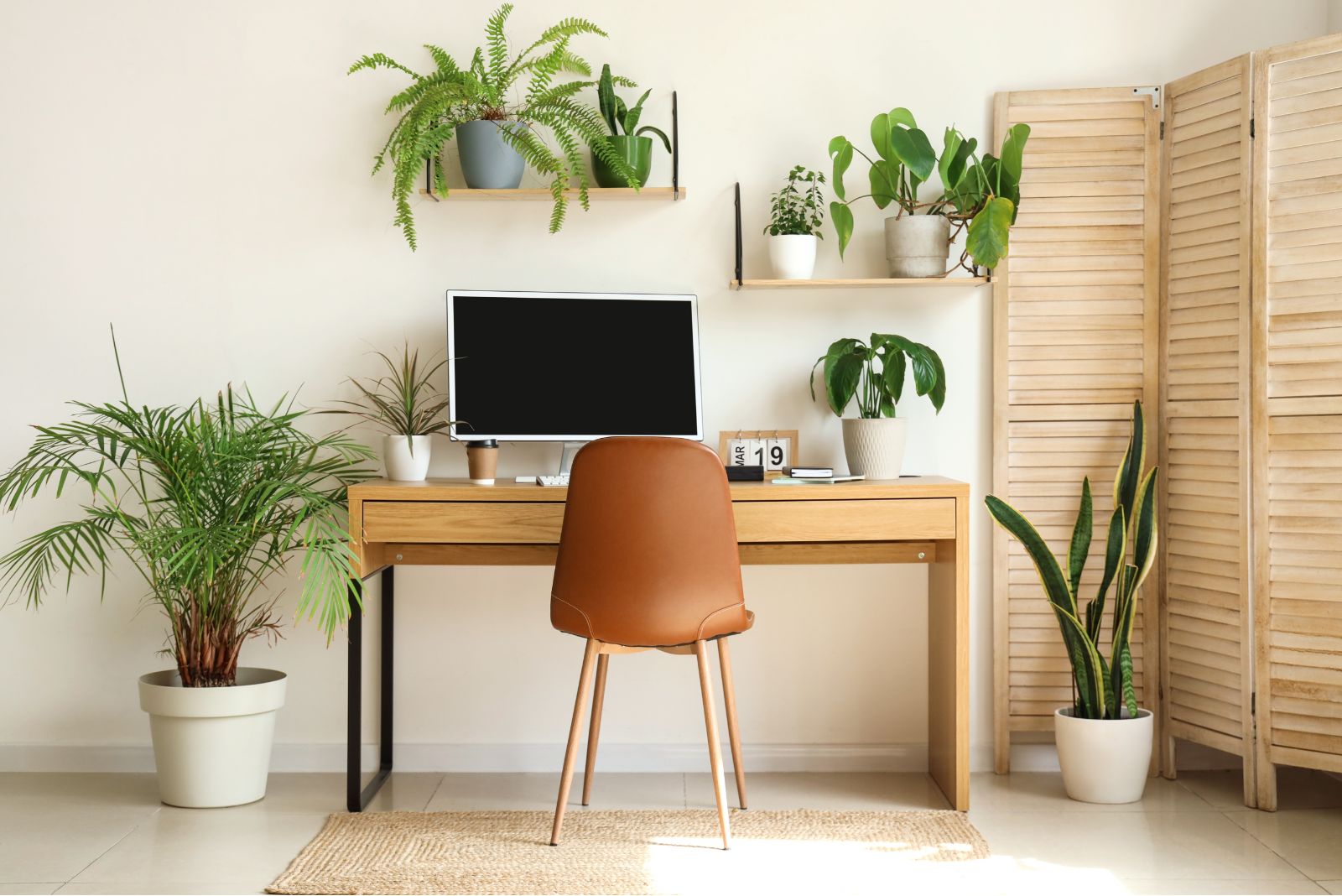 Simple home office with plants and an orange chair