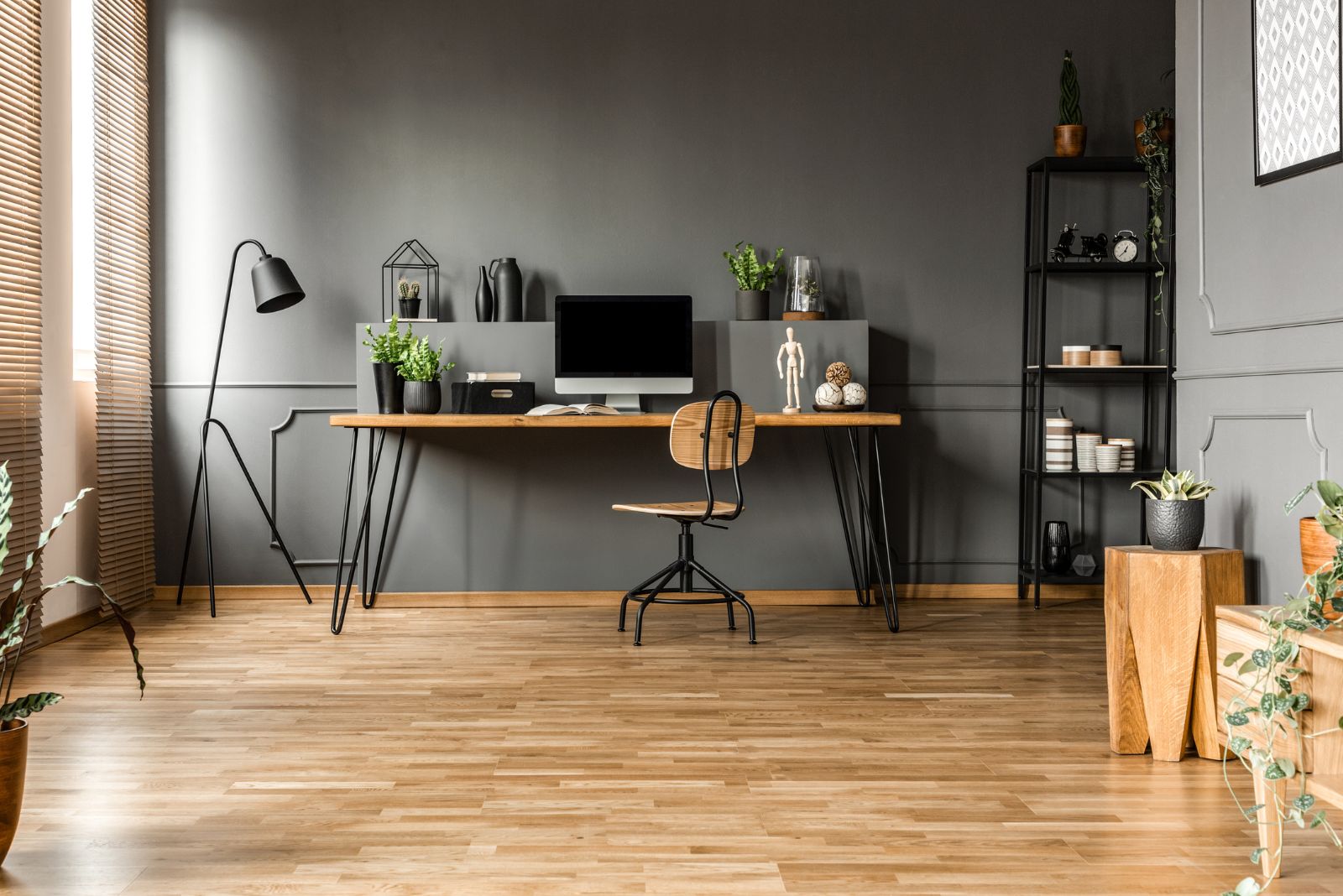 Home office with a wooden floor, gray wall and a modern design