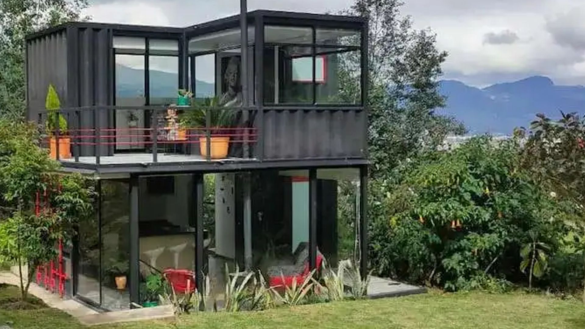 exterior of a container house with floor to ceiling windows, surrounded by nature