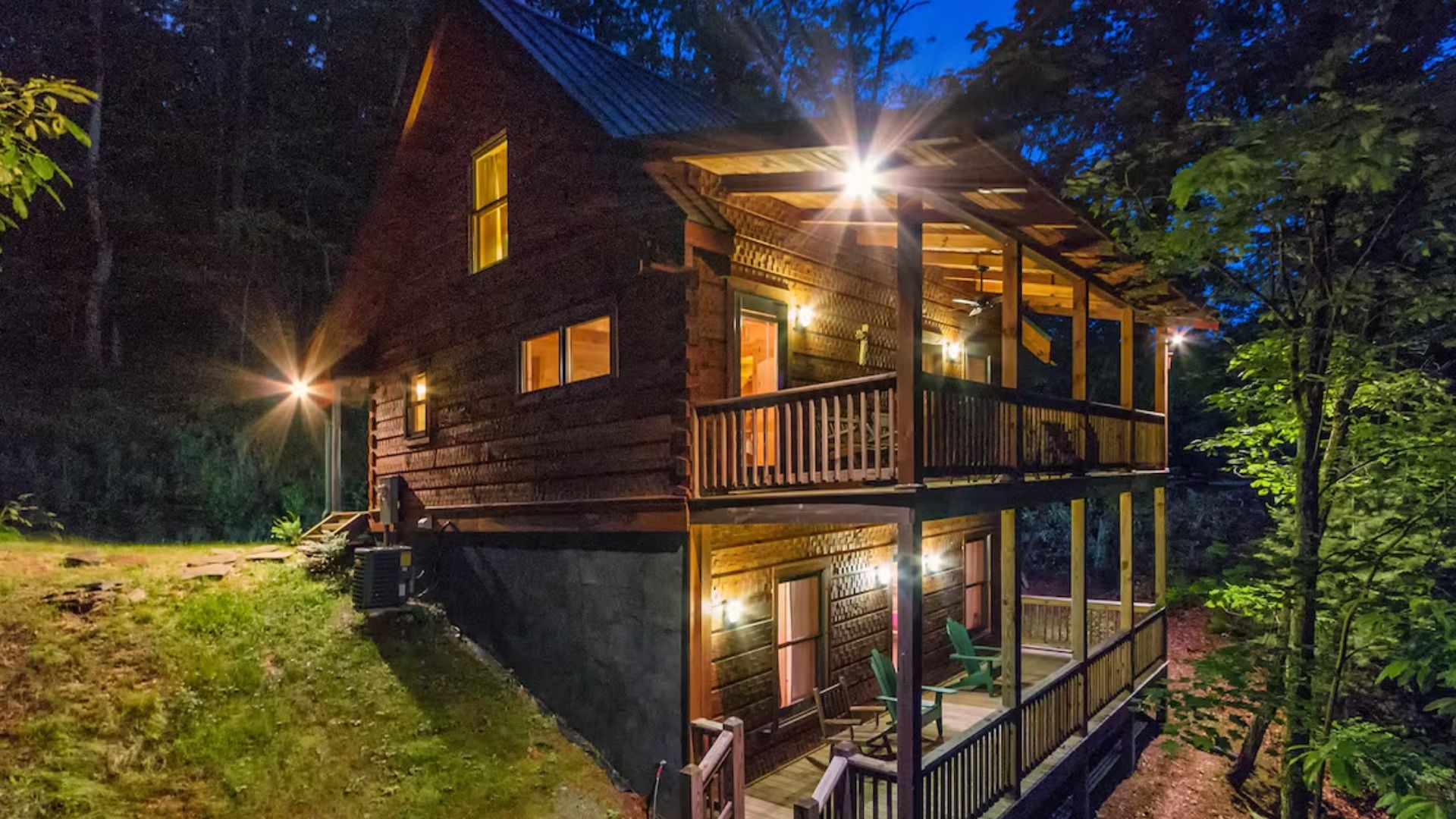 Exterior of a wooden cabin with a green roof at night