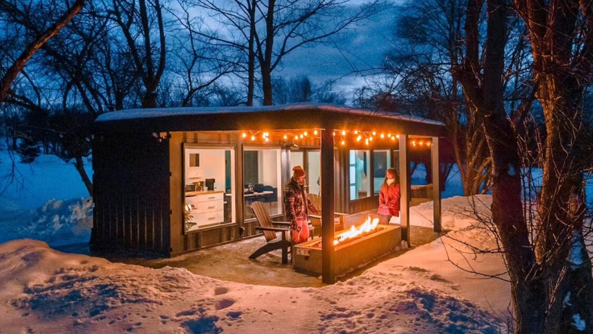 tiny container house from the outside with a hot tub on the side and two people in it