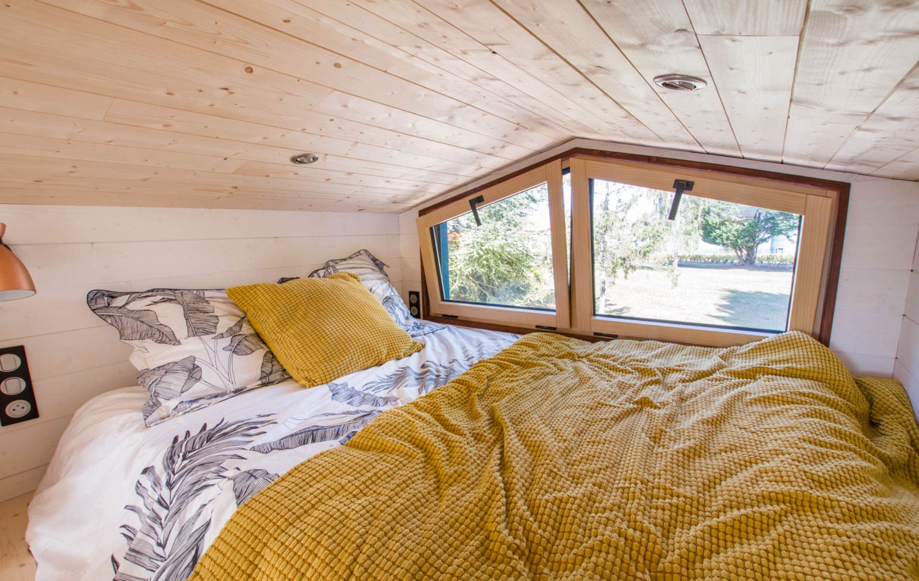 loft bedroom with a full-sized bed and yellow bedding