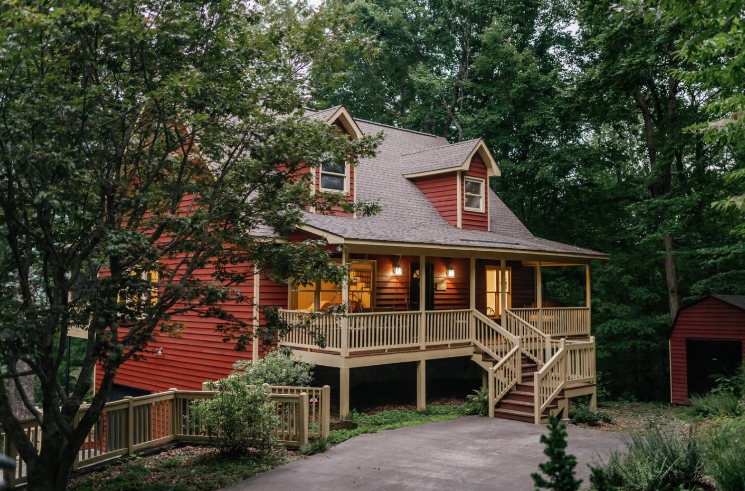 Stunning red cabin in the woods with a deck