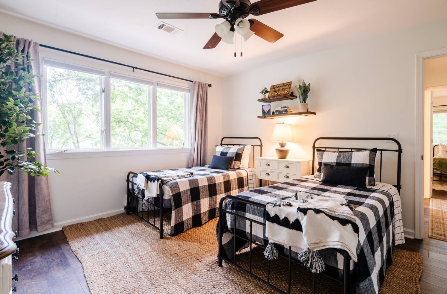 Smaller bedroom with two rustic-styled bed and a ceiling fan