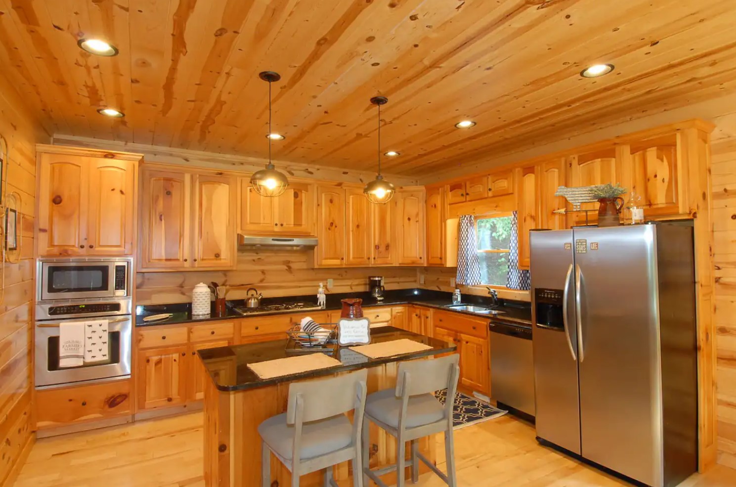 Spacious wooden kitchen with a gray fridge and an island