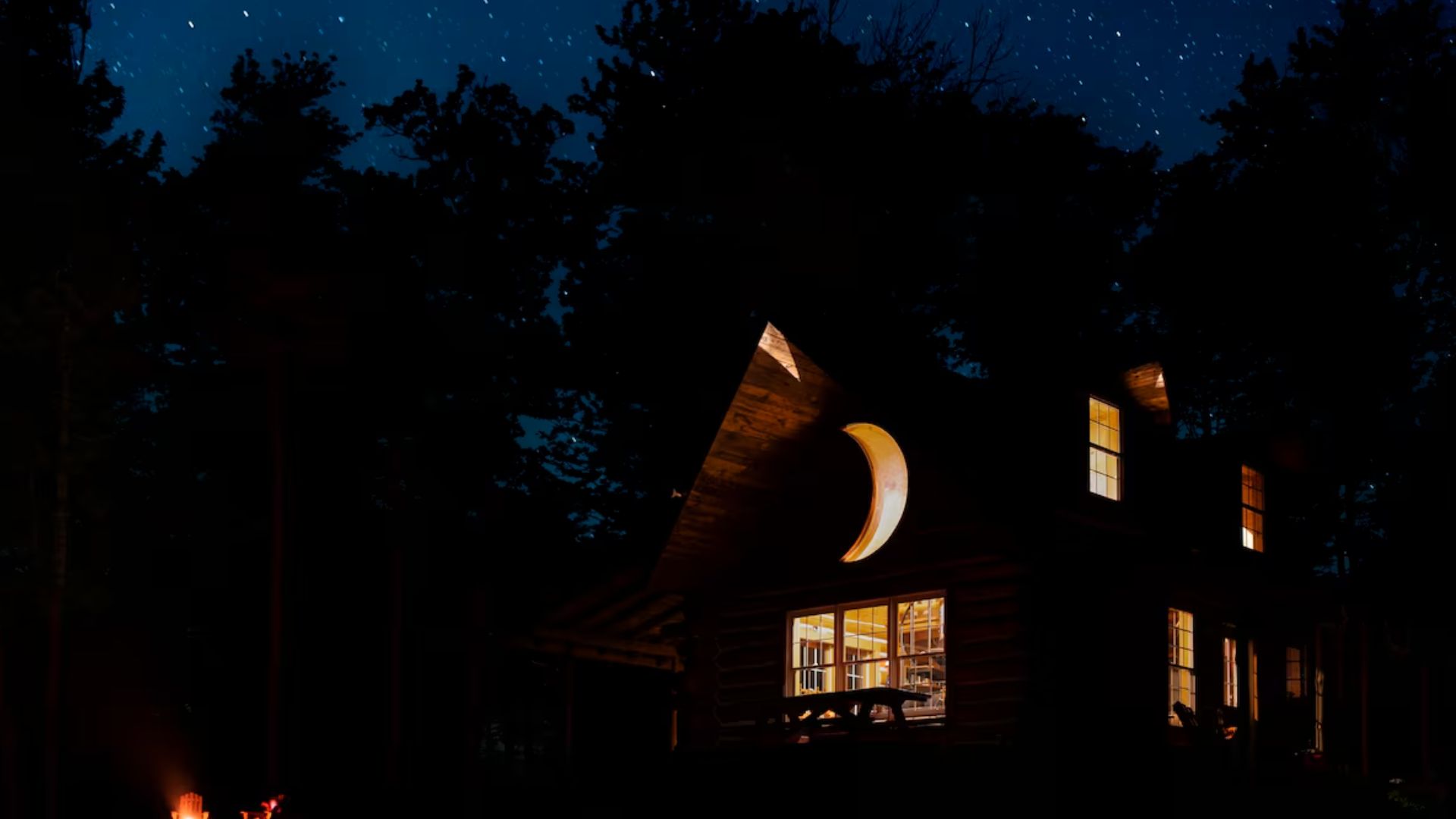 cabin at night with a crescent moon window