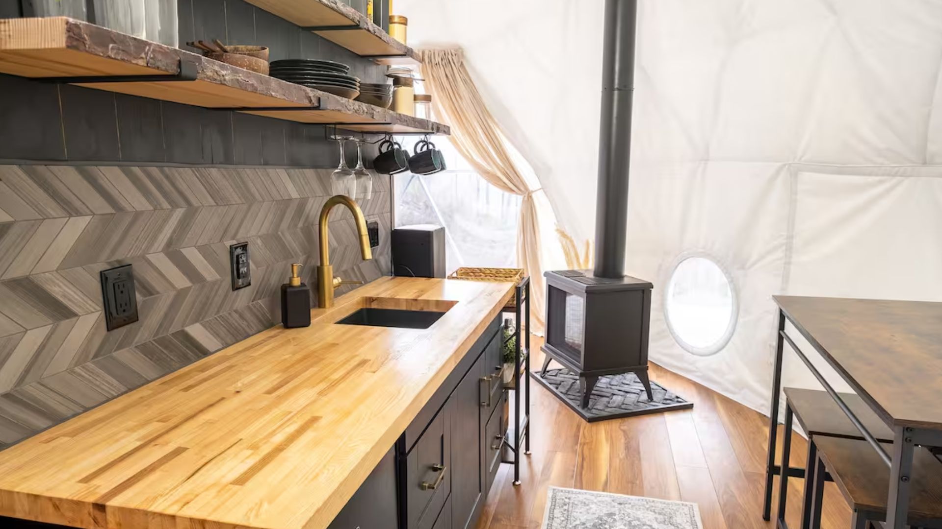 sleek industrial kitchen with uniue backsplash and a fireplace in the back