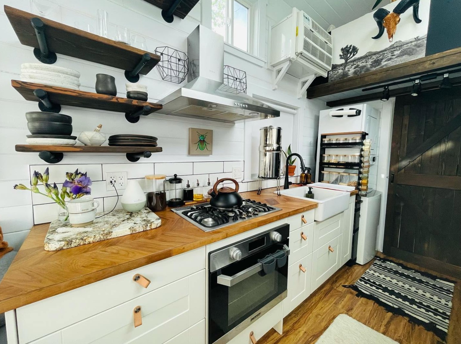 White kitchen in a tiny home with open shelves