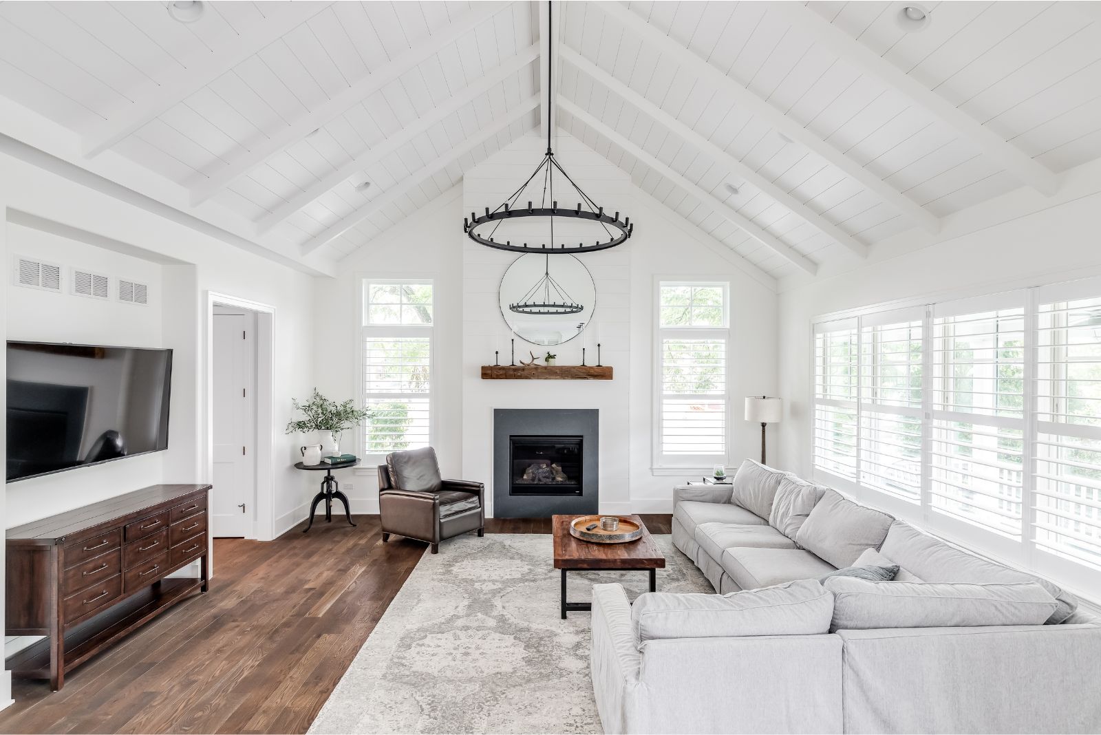 White modern living room with wooden ceiling and a black light fixture