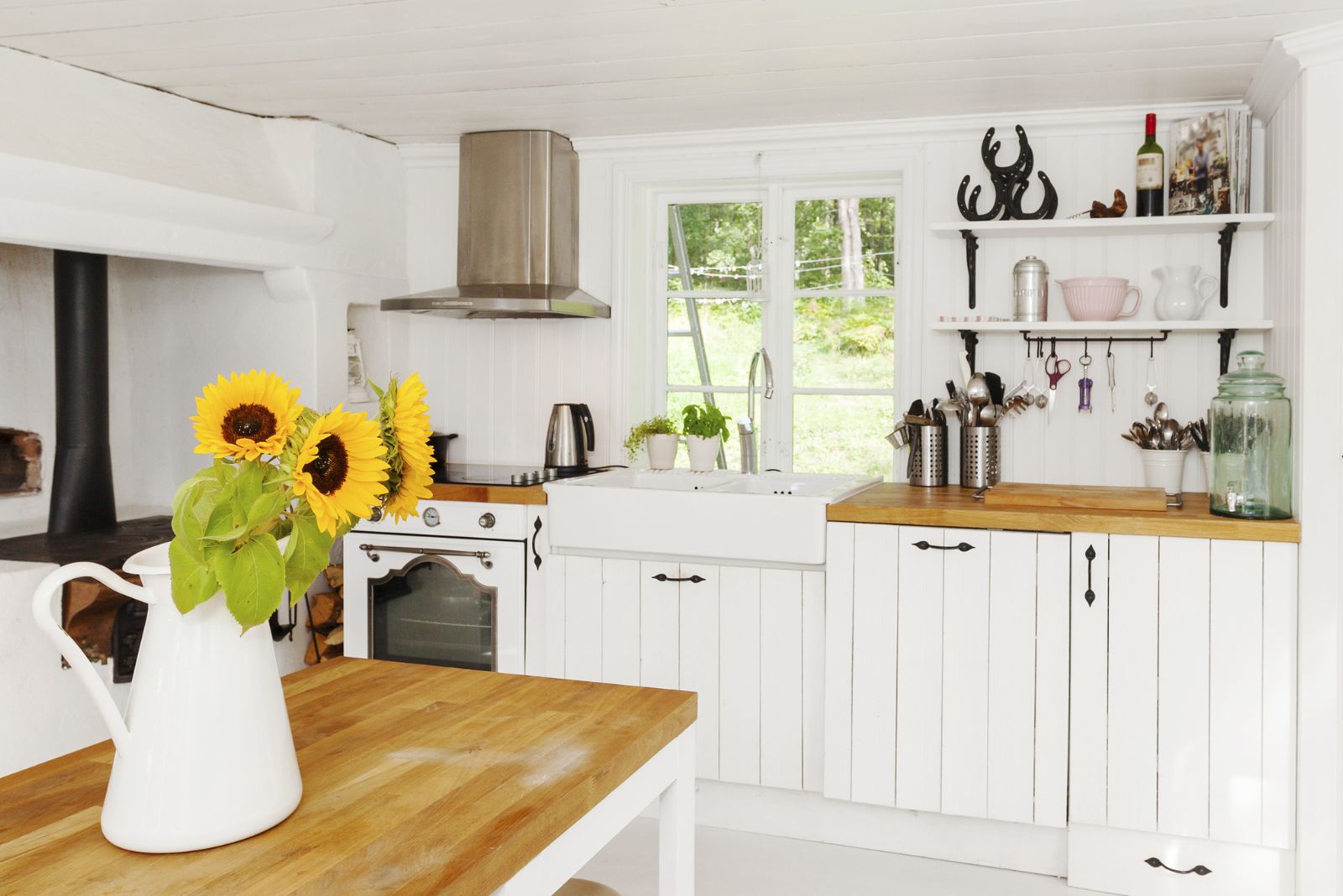 White wooden kitchen with a window by the sink