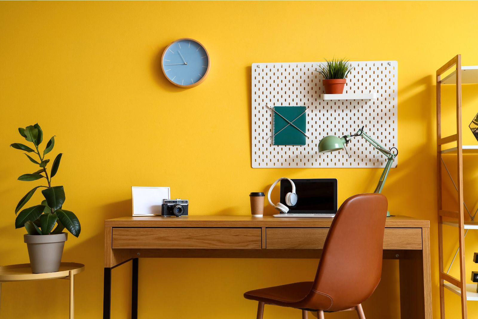 Yellow home office with an orange chair and a wooden desk