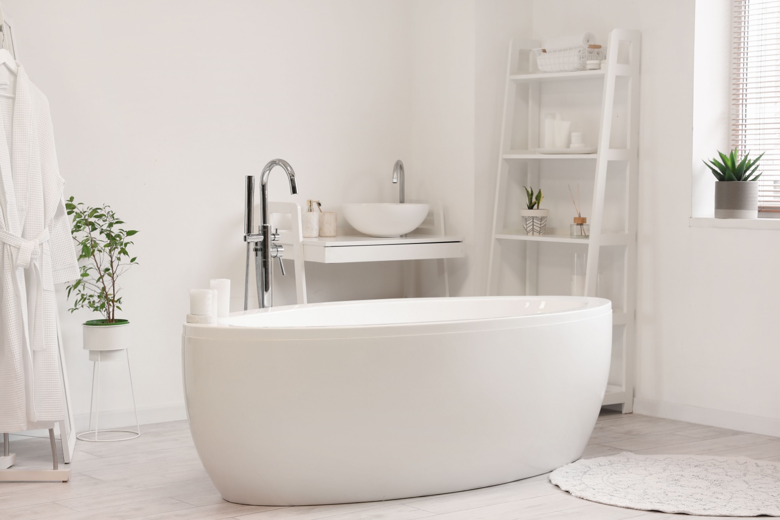 all white bathroom with a white bathtub, white shelves of different sizes, round white carpet