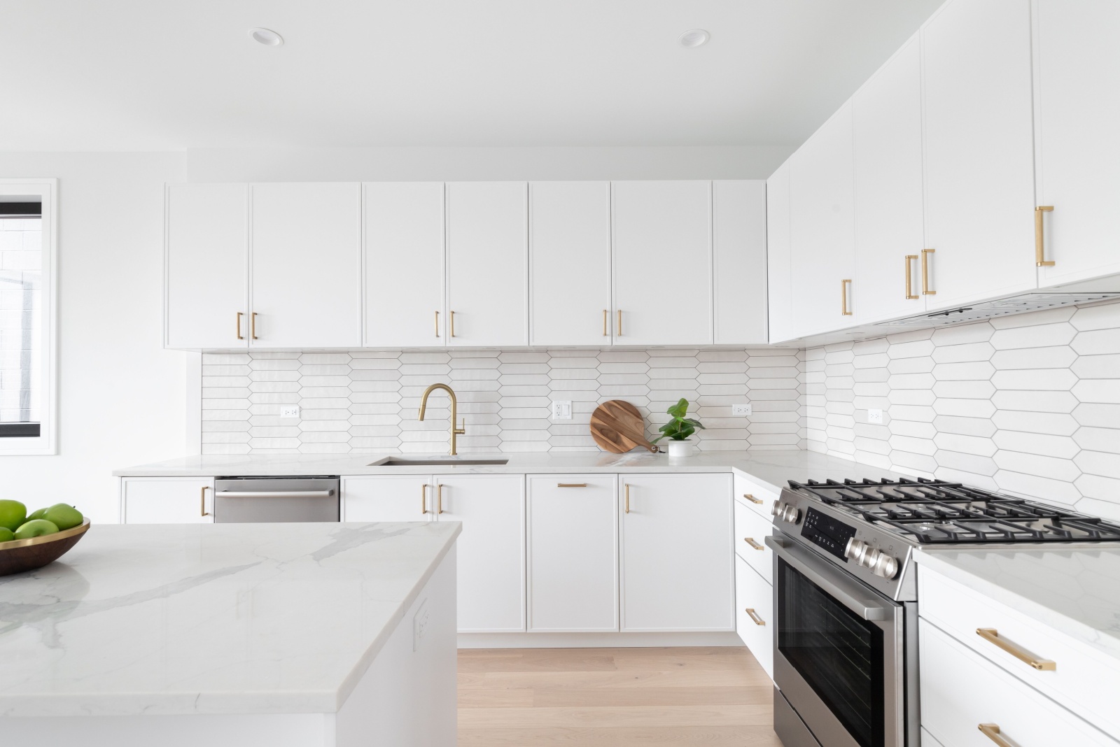 kitchen with white cabinets, white tiles and white walls, white island and white countertop