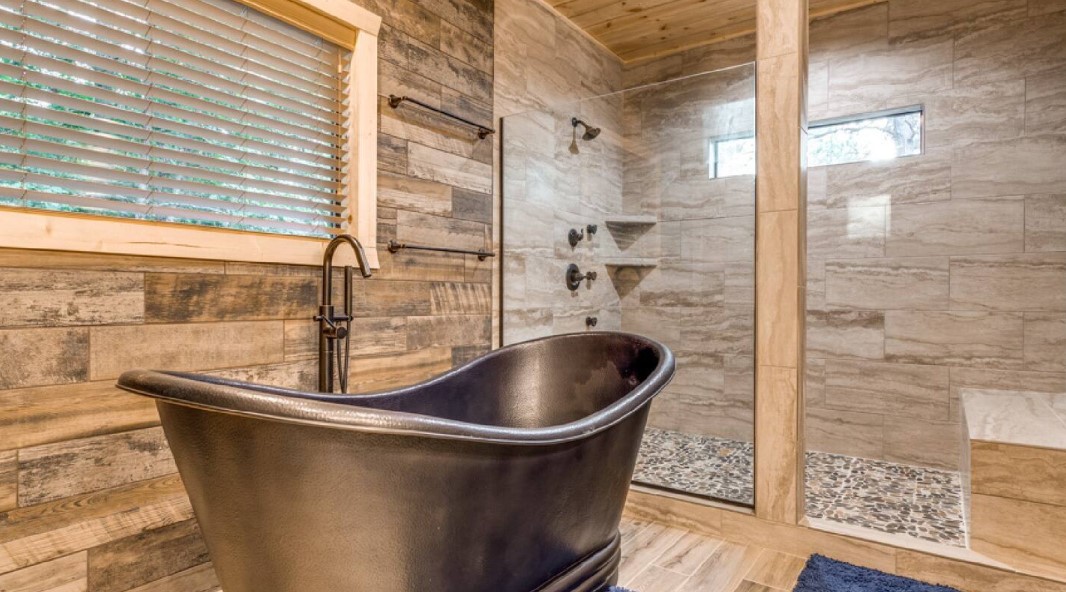 bathroom with glass shower and a black bathtub