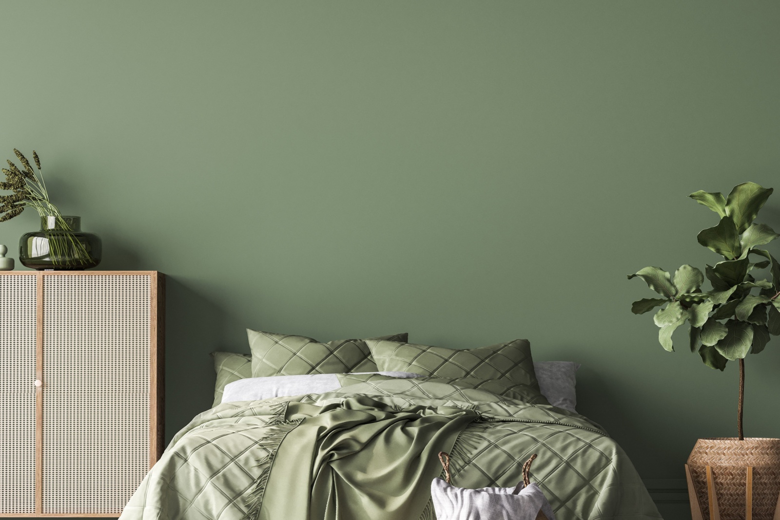 bedroom with a green wall, a bed with green bed sheets, plants on both sides of the bed and a brown cabinet