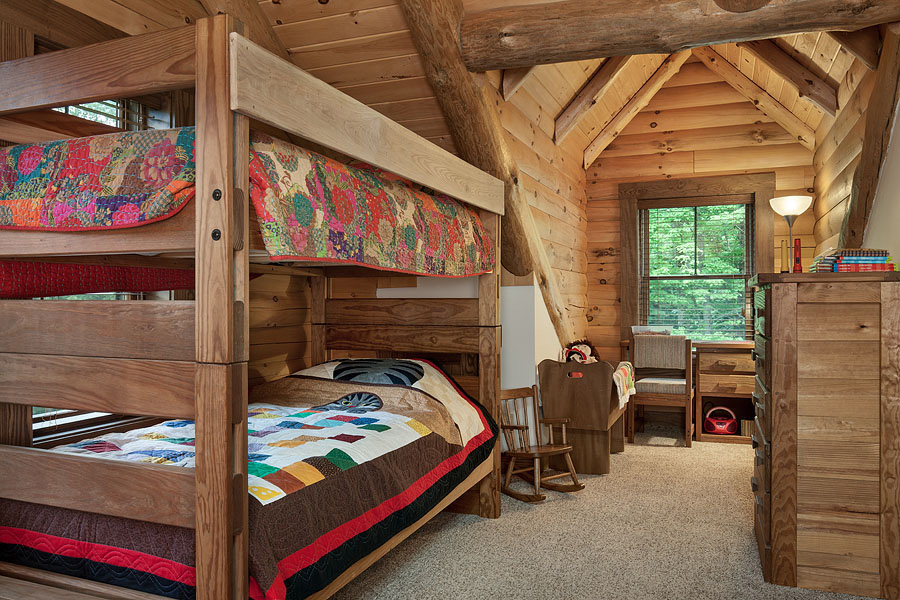 bedroom with bunk beds with wooden bed frames, white cabinet, colorful bed sheets