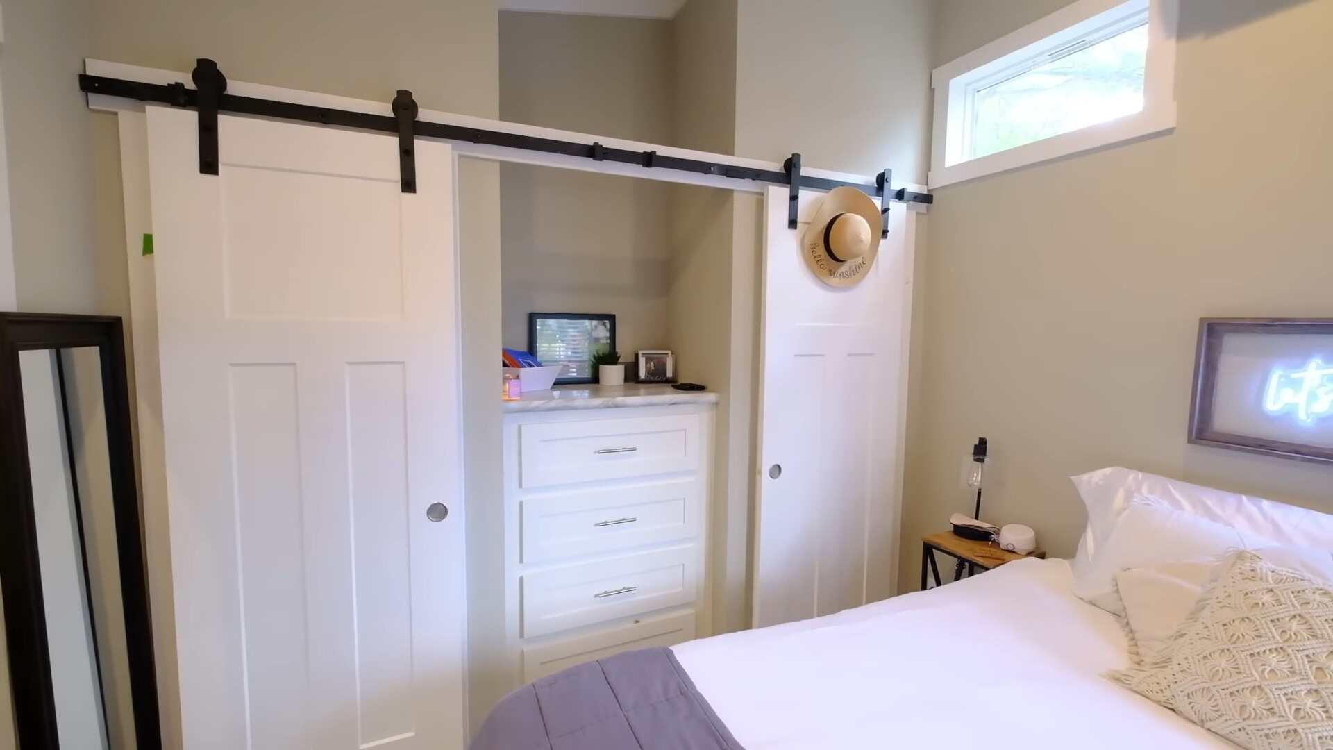 bedroom with two big white built-in closets and one white cabinet and a rectangular window