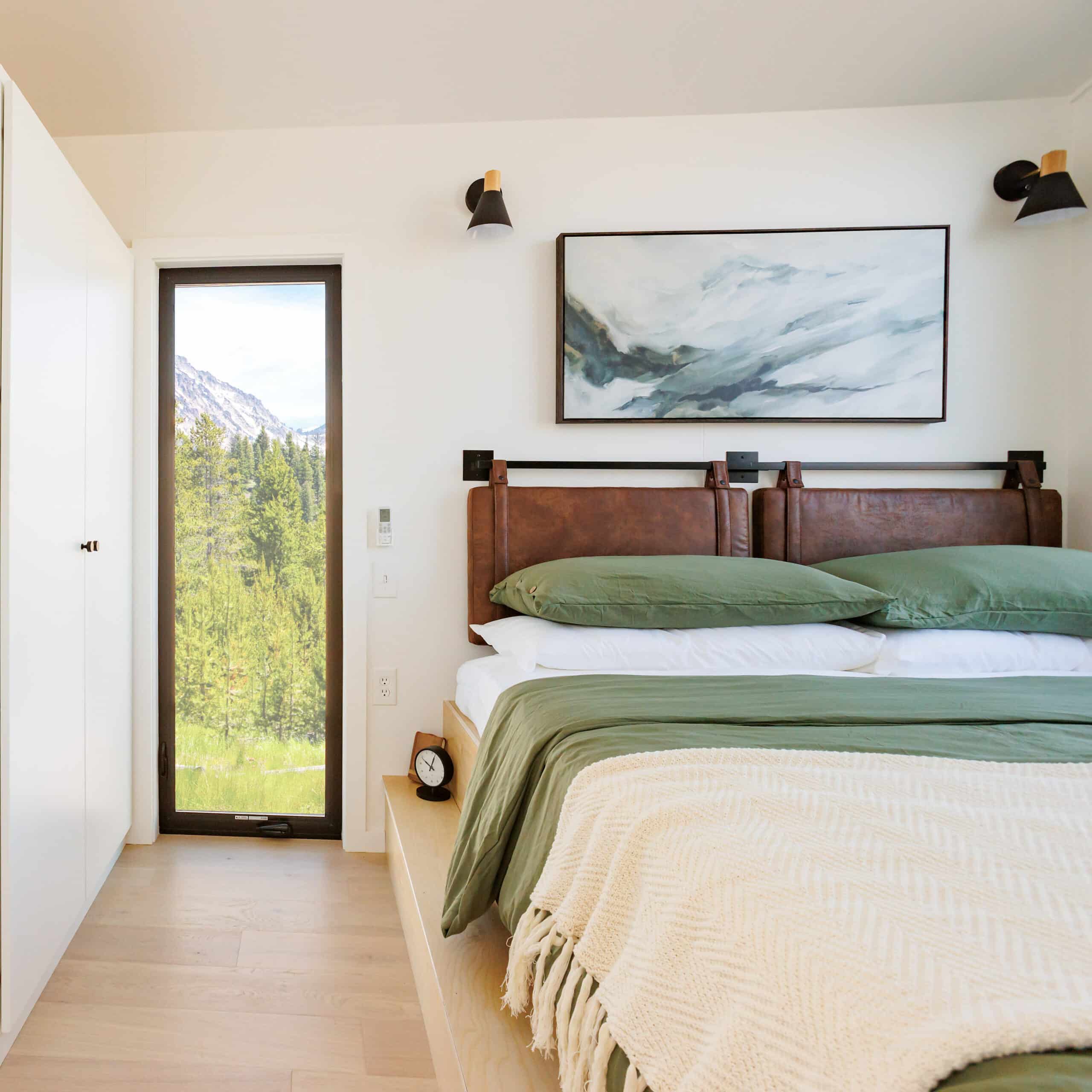 bedroom with a bed with leather bed frame, floor to ceiling window, white closet