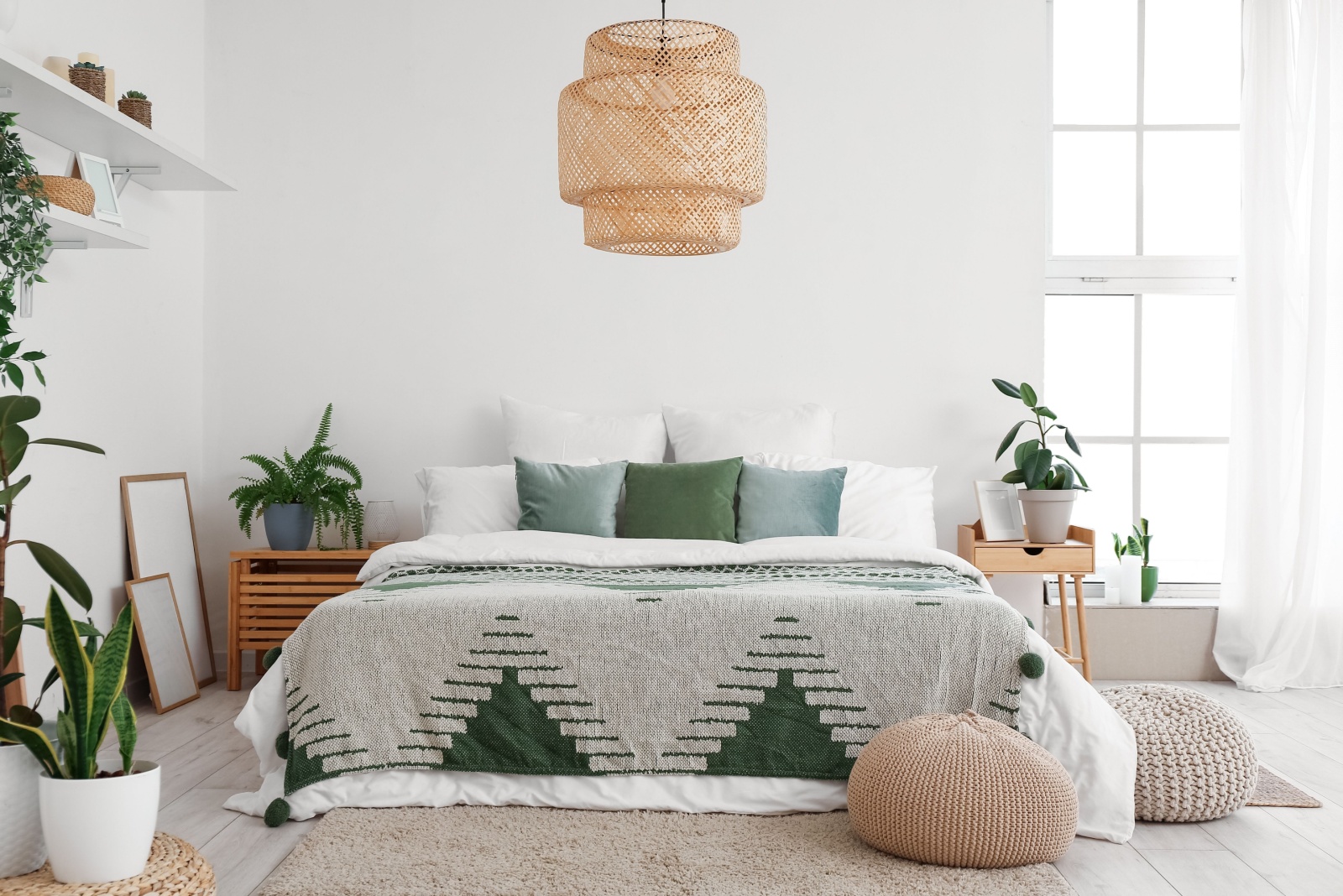 bedroom with a comfortable bed, a big chandelier above the bed, brown bedside tables and white curtains