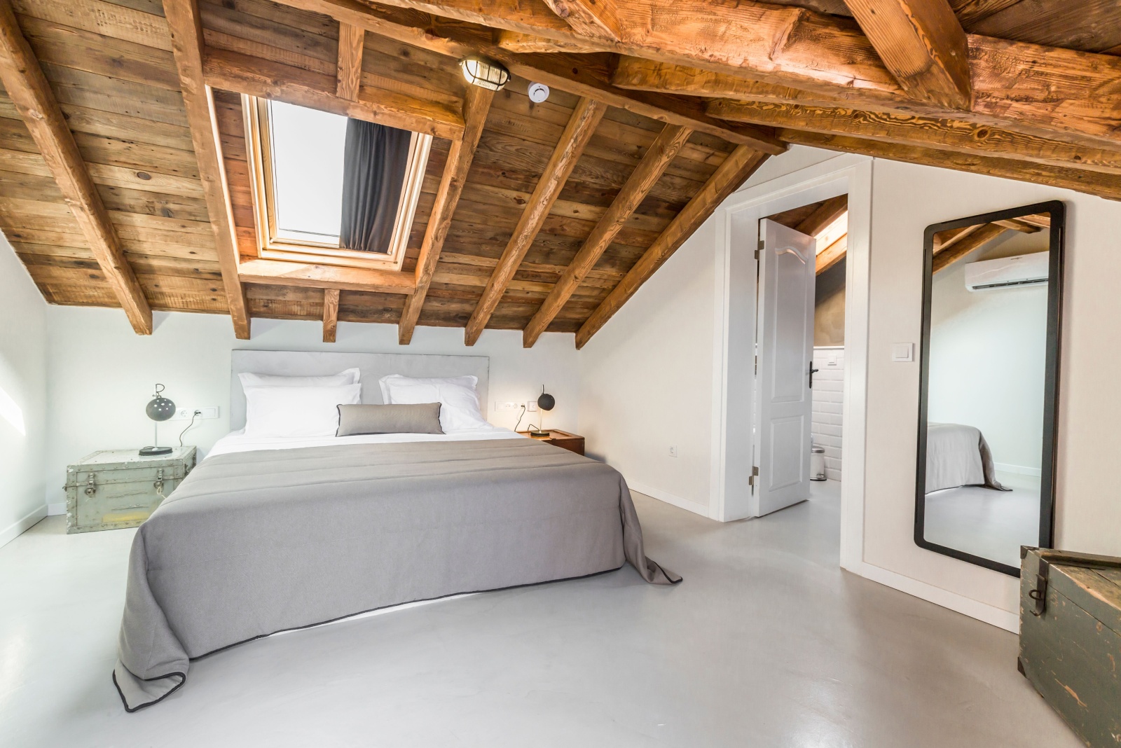 bedroom with white walls and wooden ceilings