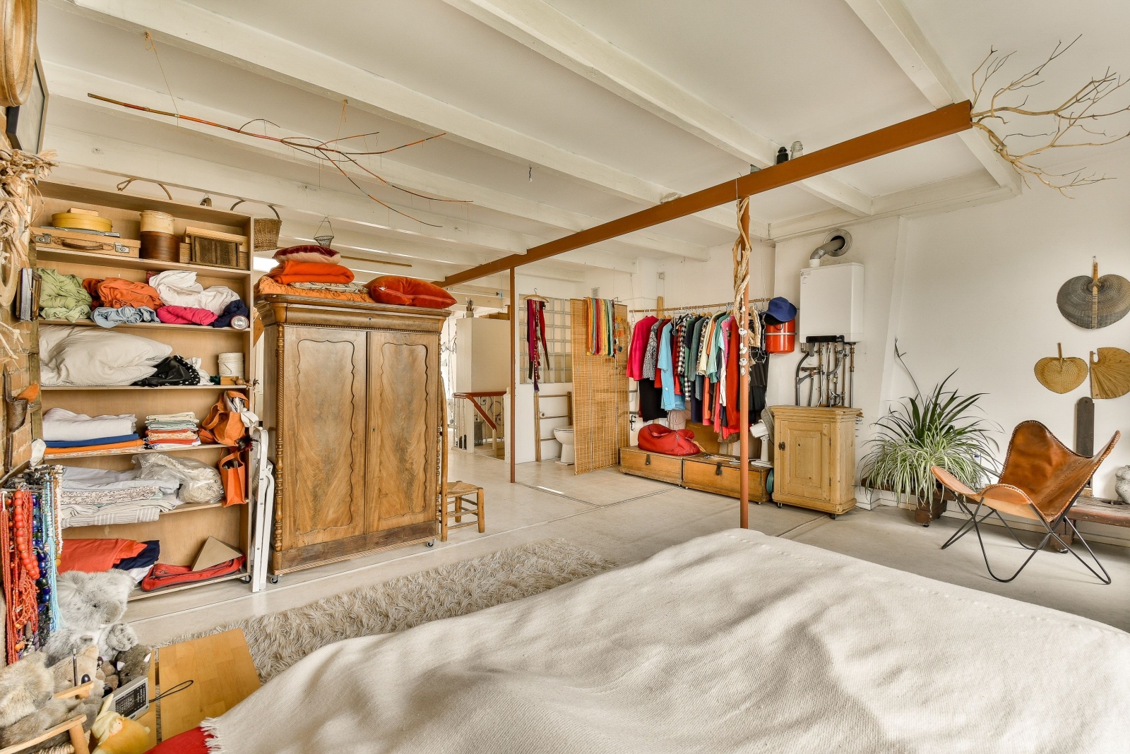 bedroom with open shelves and an open clothing rack