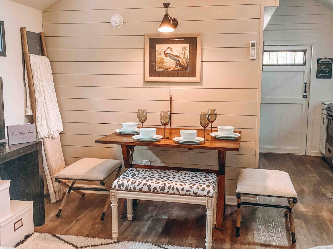 brown dining table with chairs around it, a photo hung on the wall above it