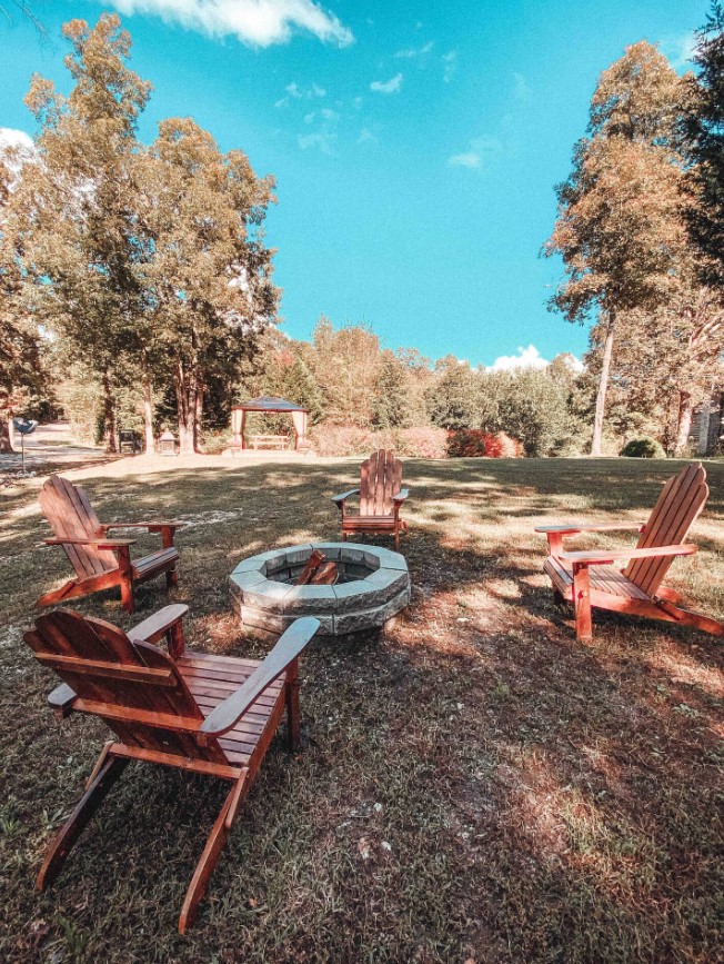 fire pit surrounded by brown, wooden chairs