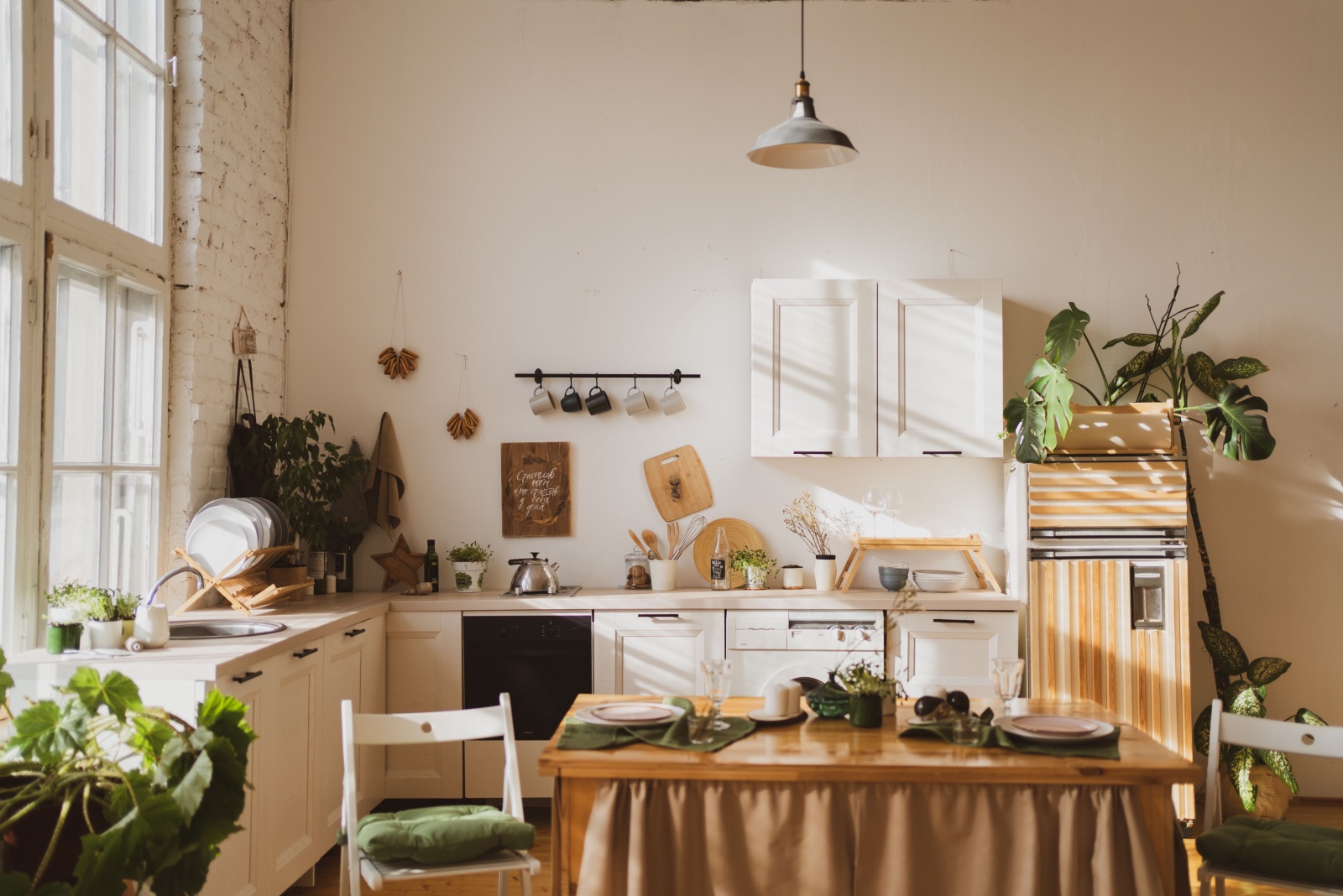 cozy kitchen with big windows, wooden decor, white cabinets and a lot of plants